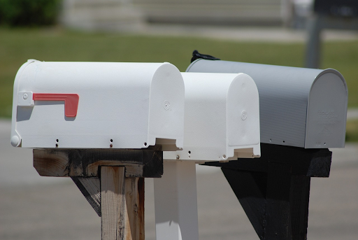 two white mailboxes and one gray mailbox