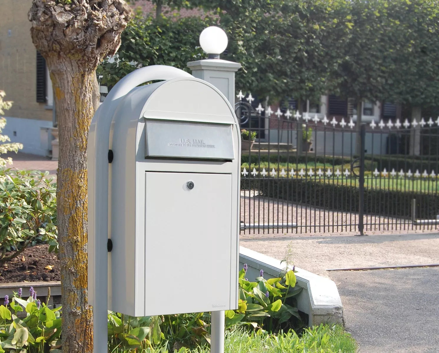 White Bobi Grande mailbox mounted on a white post, digitally edited for reference